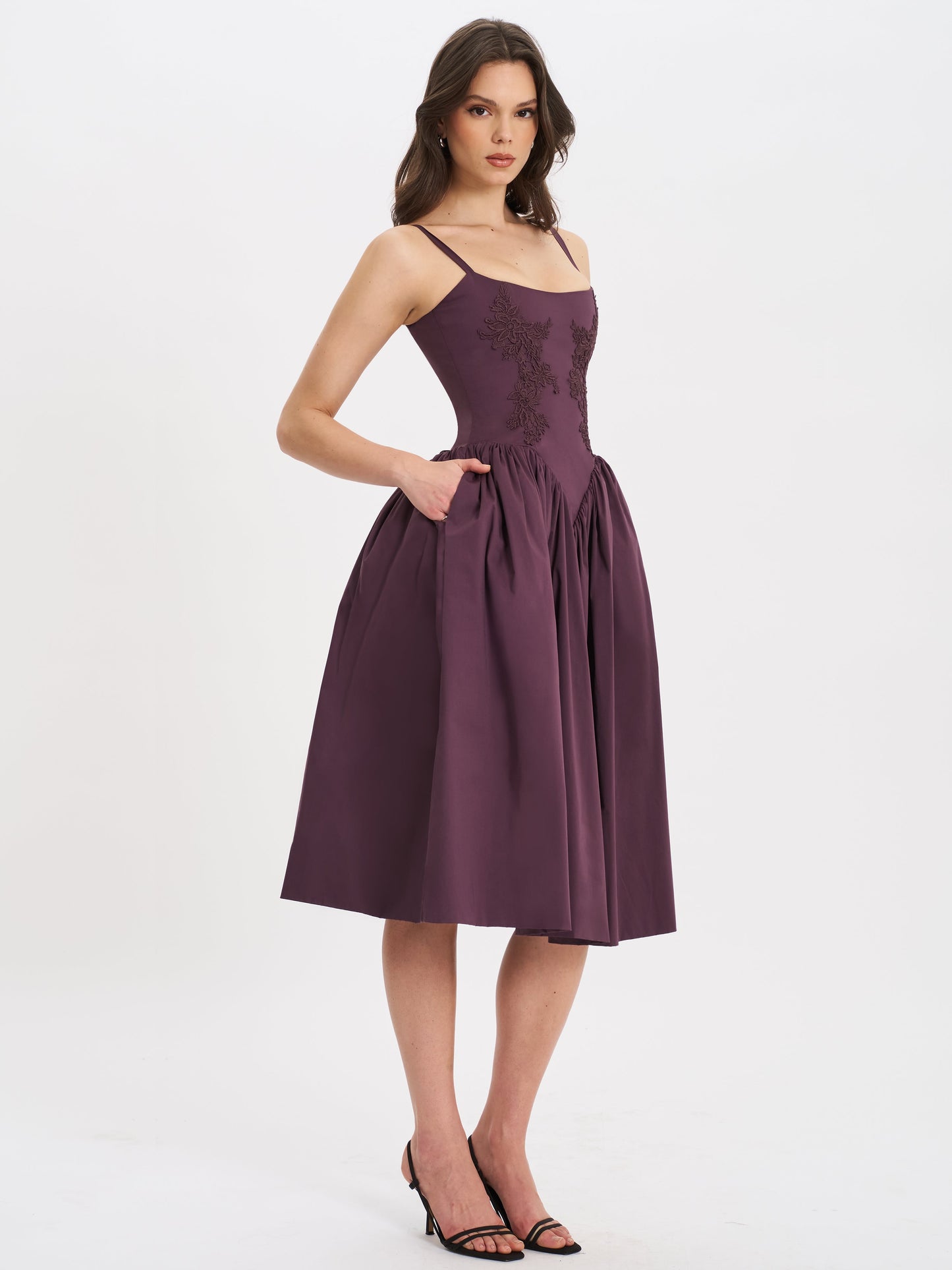 Back view of purple lace midi dress showing pleated skirt details and square neckline.