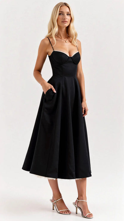 Black corset-style midi dress with a pleated skirt and side pockets — side view.