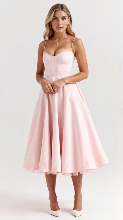 Pink corset-style midi dress with pleated skirt and tulle hem — styled frontal look.