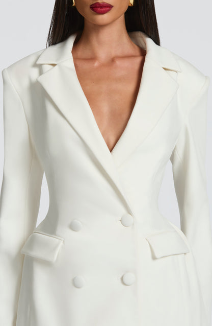 White blazer mini dress — close-up of lapels, covered buttons, and tailored seams.
