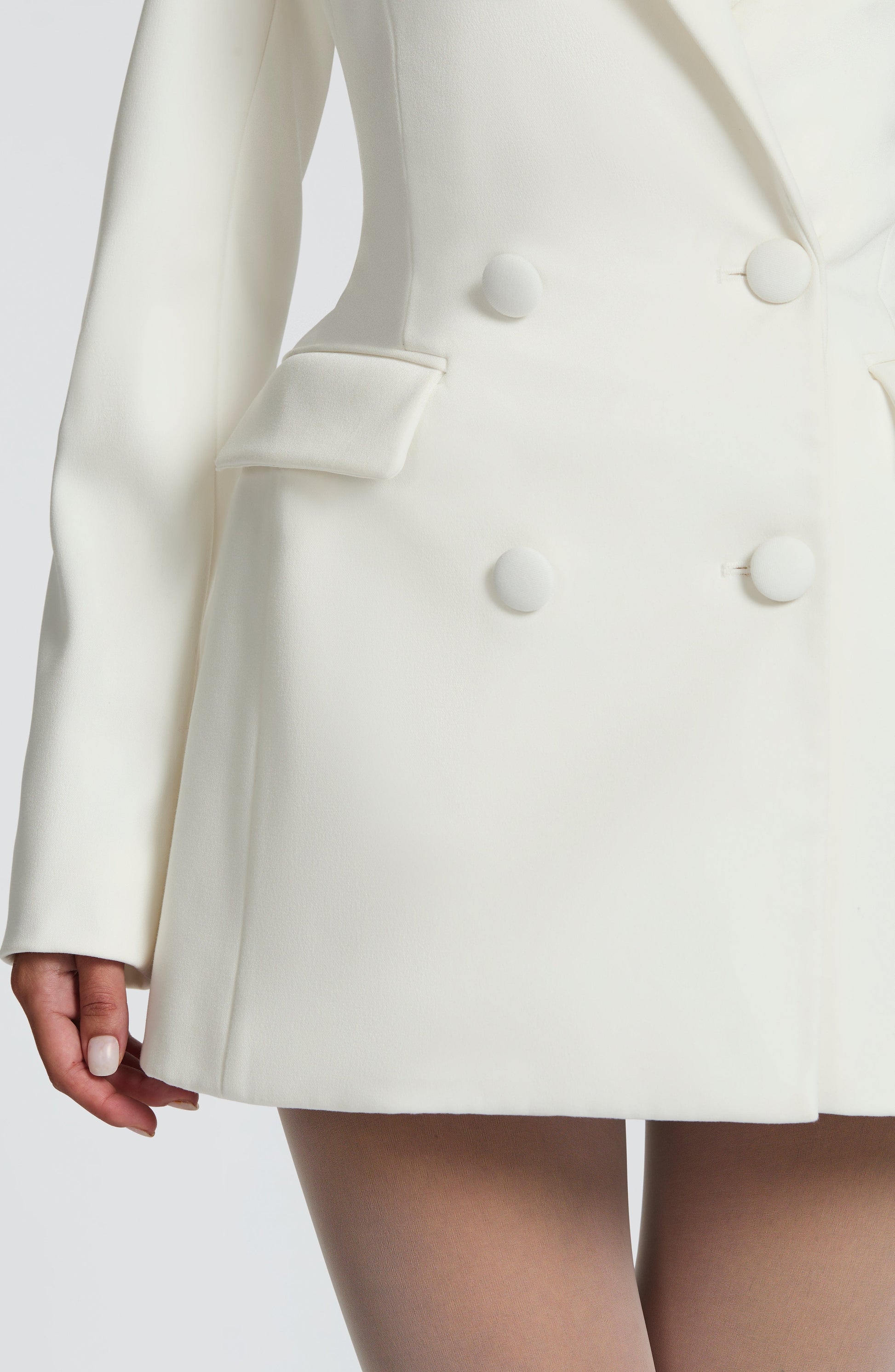 White blazer mini dress — side view showing sharp contouring through the waist.