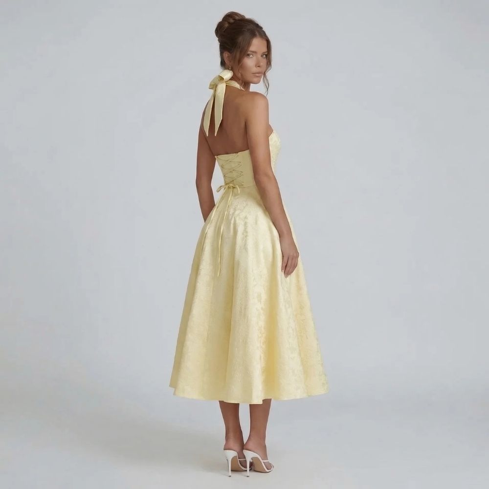 Yellow jacquard halter midi dress with bow-tied back — back view highlighting the corset detail and halter bow closure.