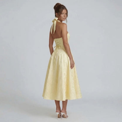 Yellow jacquard halter midi dress with bow-tied back — back view highlighting the corset detail and halter bow closure.
