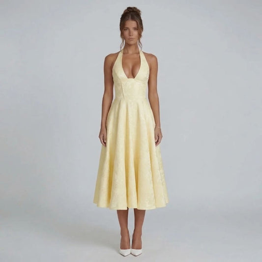 Yellow jacquard halter midi dress with bow-tied back — front view showcasing the fitted bodice and flowing skirt.