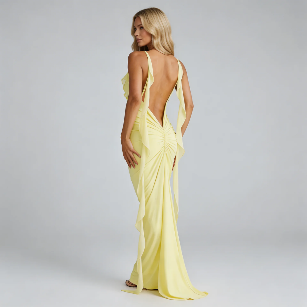 Yellow bodycon maxi dress with open back ruched design and draped side panels — back view.