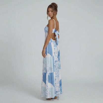 Blue and white patchwork print maxi dress — side view showcasing open back with statement bow detail.