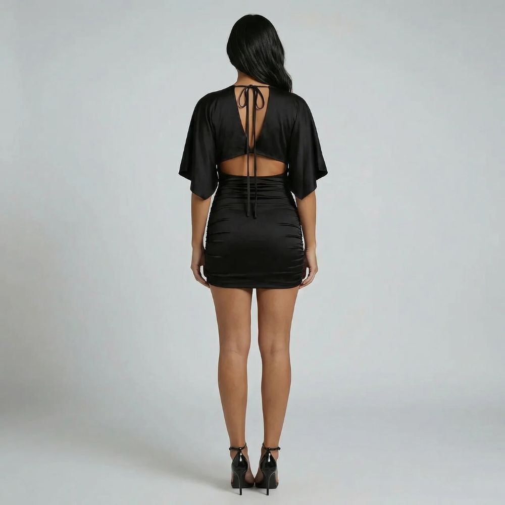 Black ruched mini dress with tie-back and cutout detail — back view highlighting the subtle, sculpted fit.