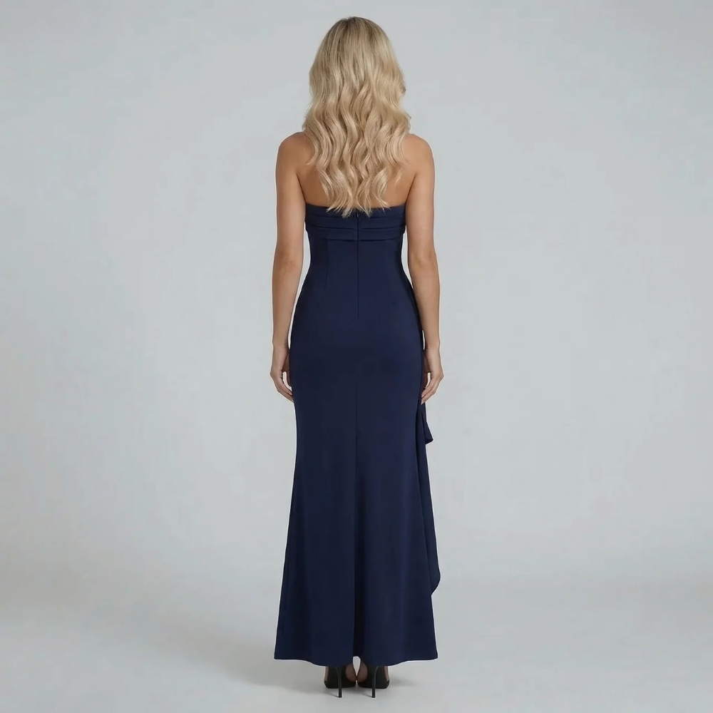 Black strapless maxi dress with high slit, styled on model in pointed heels.