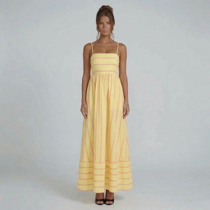 Yellow striped maxi dress with straight neckline and spaghetti straps — full front view styled with black heels.