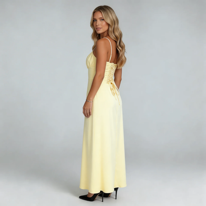 Cream lace-up maxi dress — side view highlighting corset-style back and sweeping skirt.