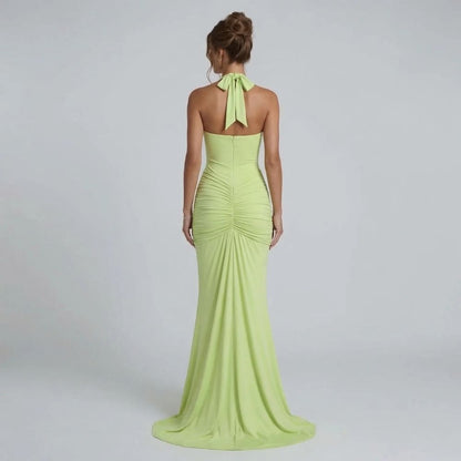 Sage halter maxi dress — back view featuring bow tie detail and sculpted ruching at the waist.