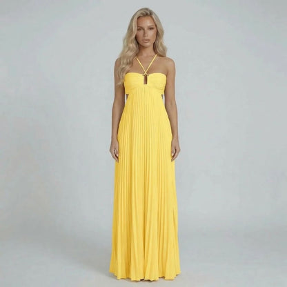 Yellow pleated maxi dress styled on model, highlighting waist cutouts and flowy skirt.