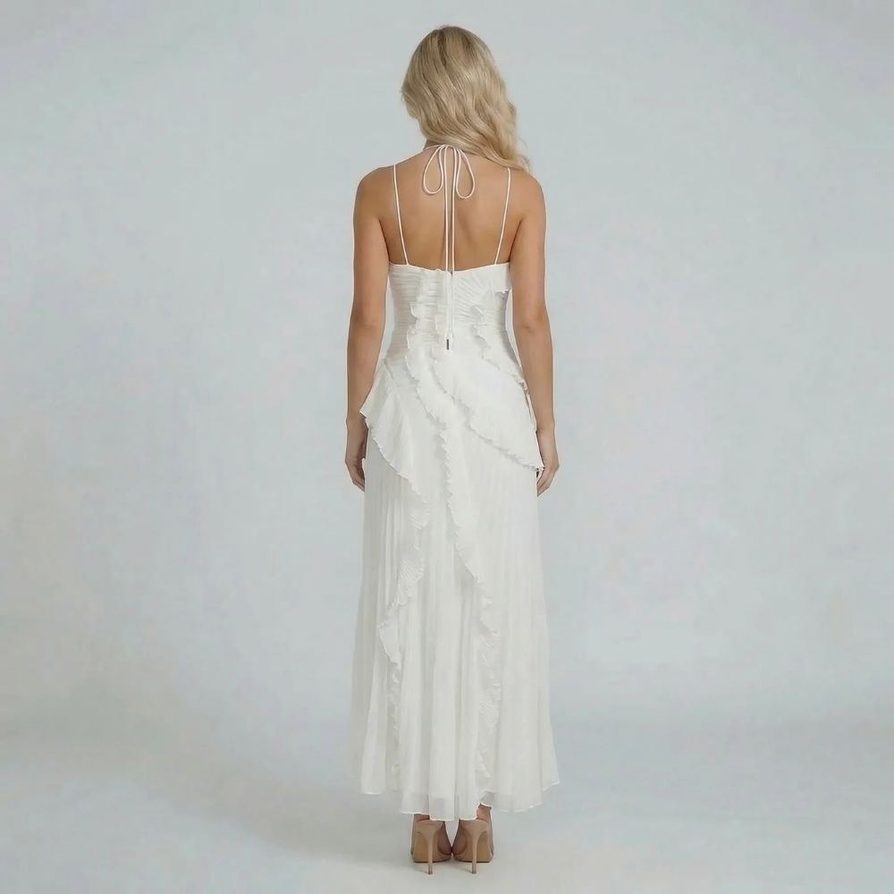 Back view of white halter maxi dress with soft ruffles — emphasizing adjustable neckline and pleated design.
