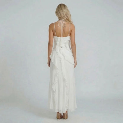 Back view of white halter maxi dress with soft ruffles — emphasizing adjustable neckline and pleated design.
