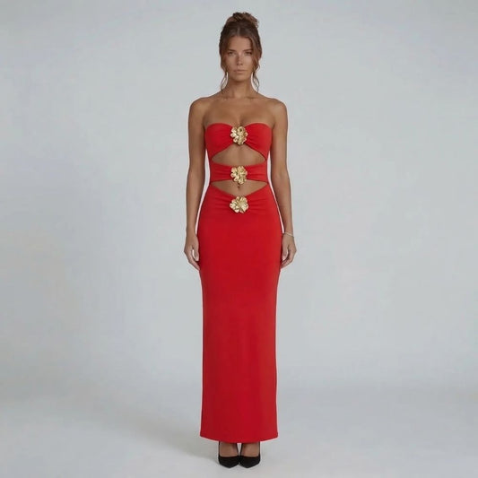 Red strapless maxi dress with bold cutouts and gold floral hardware accents — front view