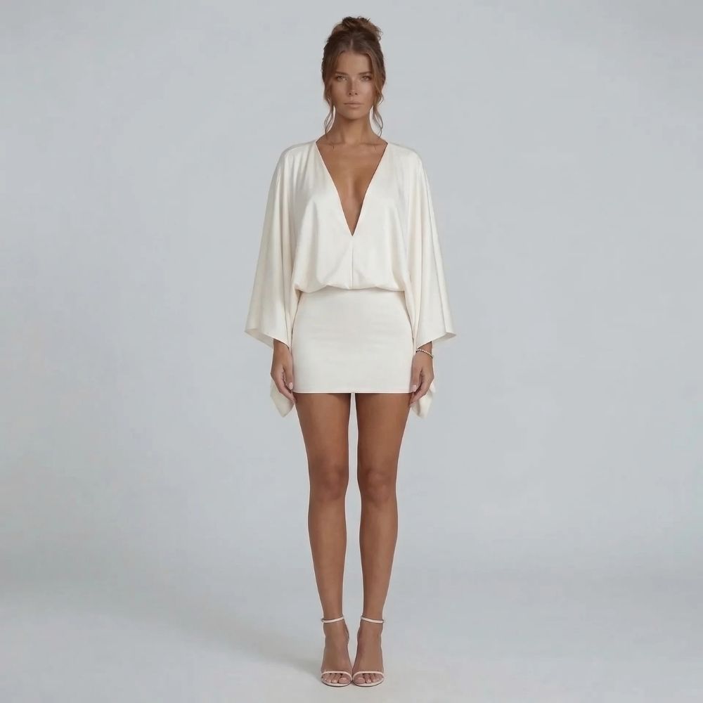 White cape-style mini dress with deep V-neckline and blouson bodice — front view showcasing sleeves.