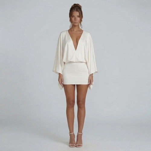 White cape-style mini dress with deep V-neckline and blouson bodice — front view showcasing sleeves.
