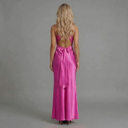 Pink twist-bust maxi dress with bow-tied open back — back view revealing dramatic bow and open back design.