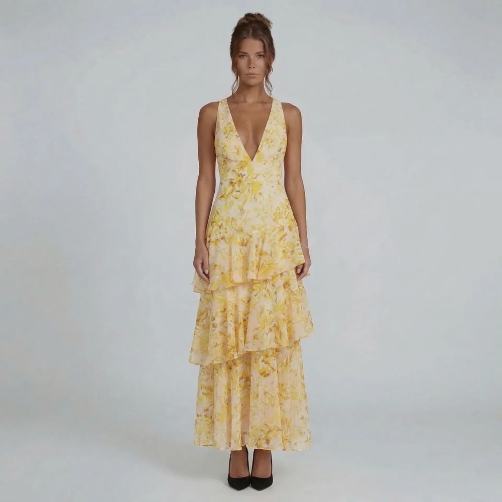 Yellow floral tiered maxi dress with cascading ruffle details — front angle.