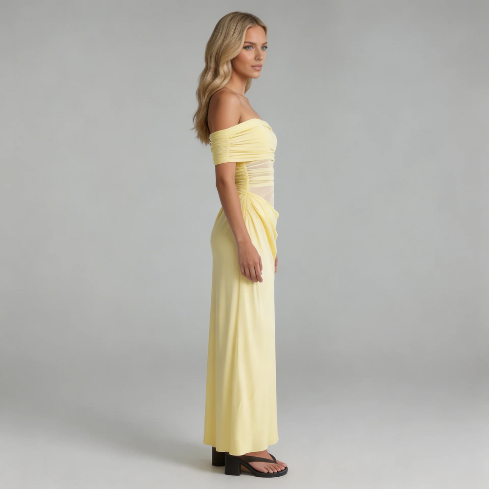 Yellow off-shoulder mesh maxi dress with ruched waist and draped skirt — side profile showcasing flowy movement.