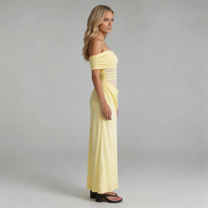 Yellow off-shoulder mesh maxi dress with ruched waist and draped skirt — side profile showcasing flowy movement.