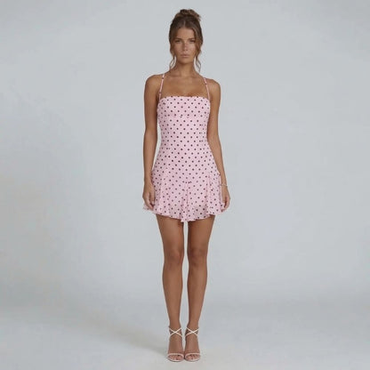 Pink polka-dot halter mini dress — front view with swishy skirt and charming print.