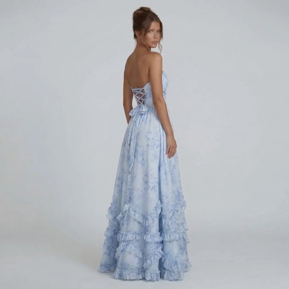 Light blue maxi dress with lace-up open back and cascading hem, back view.